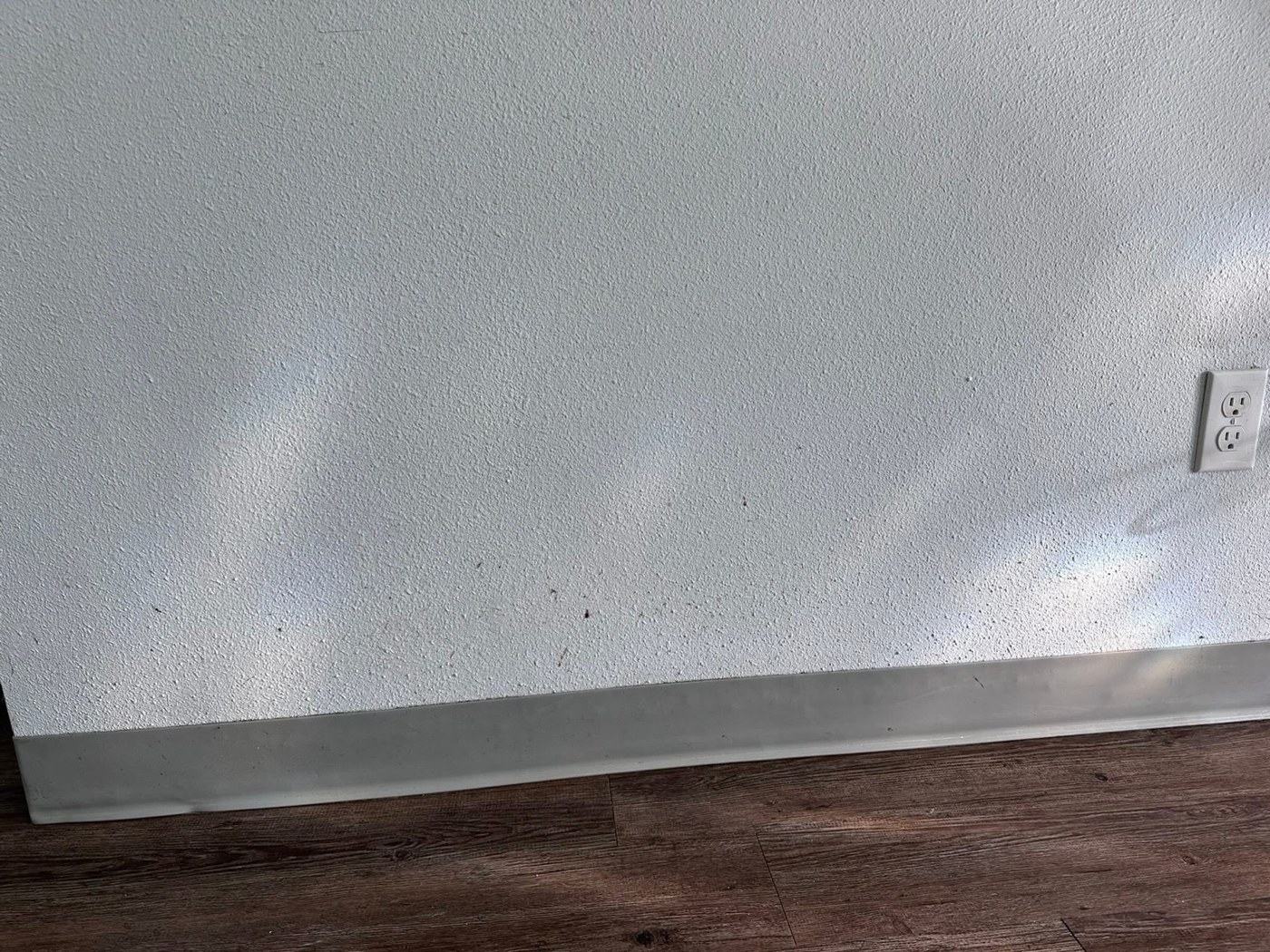 Wall and baseboard before cleaning
